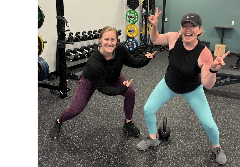 woman happily exercising with personal trainer at gym