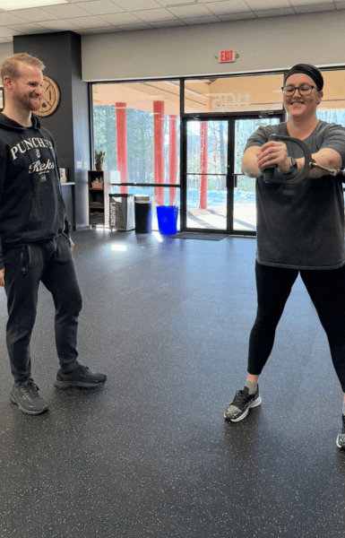 woman doing core exercise at ROI Strength gym while personal training