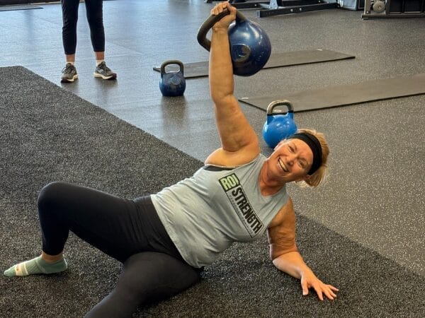 Woman Lifting Kettlebell During Strength Training at ROI Strength