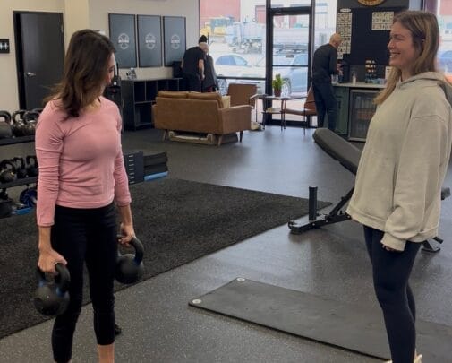 Personal Trainer Correcting Form on Strength Training Exercise at ROI Strength